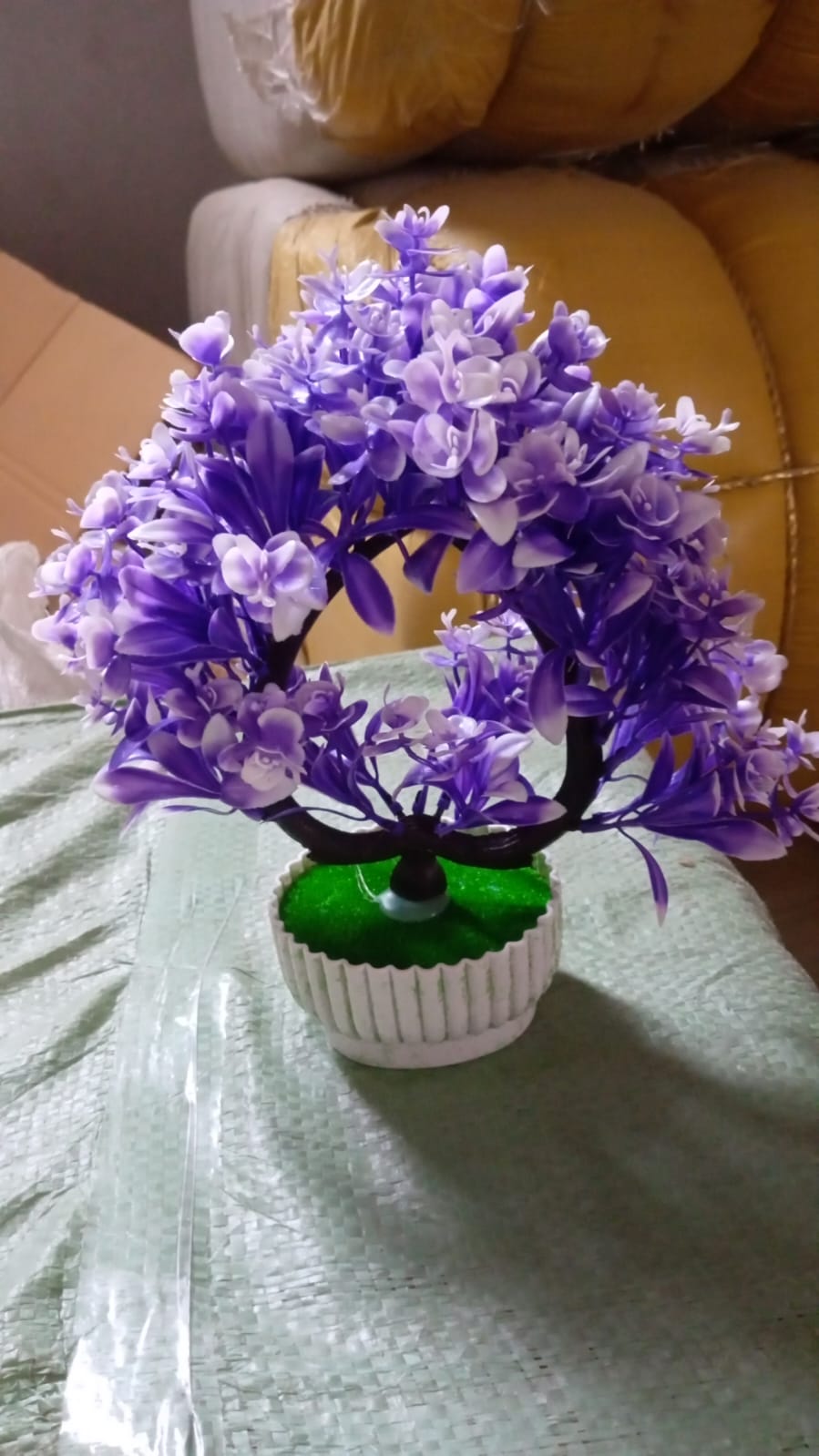 Detailed view of the artificial flower plant's foliage and pot, highlighting its low-maintenance beauty.